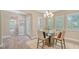 Elegant dining room with a glass table, neutral decor, and wood-look flooring, leading to the front entryway at 11603 Bluebird Pl, Lakewood Ranch, FL 34211