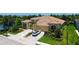 Stunning home featuring a tile roof, three-car garage, lush landscaping, and a brick driveway by a beautiful pond at 11603 Bluebird Pl, Lakewood Ranch, FL 34211