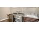 Convenient laundry room with stainless steel washer and dryer, wash basin, white wire shelving, and wood cabinets at 11603 Bluebird Pl, Lakewood Ranch, FL 34211