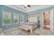 Serene main bedroom with tray ceilings, a seating bench, and natural light streaming through plantation-shuttered windows at 11603 Bluebird Pl, Lakewood Ranch, FL 34211