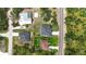 This aerial shot showcases the house roof and driveway in relation to the road, nearby houses, and landscaping at 11960 De Leon Dr, North Port, FL 34287