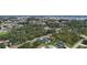 See a broad view of the house's neighborhood, tree coverage, yards, and landscaping in the region from an aerial perspective at 11960 De Leon Dr, North Port, FL 34287