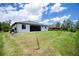 An exterior view shows this home's lawn, landscaping and screened porch, as well as the neighboring property at 11960 De Leon Dr, North Port, FL 34287