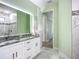 Bathroom with double sink vanity, stylish mirror, and tiled walls and floors at 11960 De Leon Dr, North Port, FL 34287