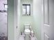 Bright water closet with a decorative window and a view into a tiled, marble walk-in shower at 11960 De Leon Dr, North Port, FL 34287
