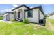 A close exterior view shows this home's nice lawn and landscaping that leads to a covered front entrance at 11960 De Leon Dr, North Port, FL 34287