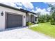 A sunny view of this home's driveway, garage, lawn, and tasteful landscaping shows a home well worth owning at 11960 De Leon Dr, North Port, FL 34287