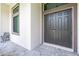 A close up of this home's front entryway and door, showing a paved walkway and seating on a covered porch at 11960 De Leon Dr, North Port, FL 34287