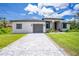 Charming single Gathering home featuring a stone driveway, a two-car garage, and well manicured landscaping at 11960 De Leon Dr, North Port, FL 34287