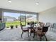 Enclosed lanai featuring a brick floor, outdoor dining set, and view of the back yard at 11960 De Leon Dr, North Port, FL 34287