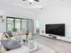 Spacious living room with sliding glass doors for access to the outdoors, a modern ceiling fan and neutral decor at 11960 De Leon Dr, North Port, FL 34287