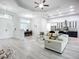 Open-concept living room flows into kitchen with wood-look floors, modern lighting and neutral decor at 11960 De Leon Dr, North Port, FL 34287