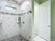 Walk-in shower featuring marble-style walls, mosaic floor, and glass door at 11960 De Leon Dr, North Port, FL 34287