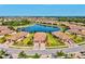 Aerial view of a community showcasing well-maintained homes, a central lake, and lush landscaping at 12230 Amica Loop, Venice, FL 34293