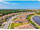 Aerial view showcases homes with tile roofs near lake, and well maintained landscaping and street at 12230 Amica Loop, Venice, FL 34293