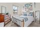 Comfortable bedroom featuring an ornate black metal bed frame, dresser, art prints and a sunlit window at 12230 Amica Loop, Venice, FL 34293