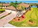 Stunning home featuring lush landscaping, brick driveway, and a three-car garage at 12230 Amica Loop, Venice, FL 34293