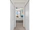 Hallway featuring closet doors with glimpse into bedroom at 12230 Amica Loop, Venice, FL 34293