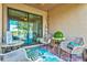 Covered patio with brick flooring, decorative rug and comfortable seating with a view of the lake at 12230 Amica Loop, Venice, FL 34293