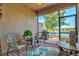 A screened in patio features comfortable seating, brick flooring, and views of the lake at 12230 Amica Loop, Venice, FL 34293