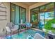 Screened patio with brick flooring, decorative rug and comfortable seating with a view of the lake at 12230 Amica Loop, Venice, FL 34293
