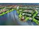 Scenic aerial view of a community with lush landscaping, winding roads, and a tranquil lake with a gazebo at 13711 Messina Loop # 102, Lakewood Ranch, FL 34211
