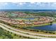 Wide angle aerial view of a golf course community, featuring homes, lakes, and lush green fairways under a sunny sky at 13711 Messina Loop # 102, Lakewood Ranch, FL 34211