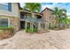 Close up exterior showcasing stone accents, palm trees, and stairways to multiple units and paved walkway at 13711 Messina Loop # 102, Lakewood Ranch, FL 34211