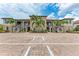 Attractive condo building exterior showcasing stone accents, palm trees, ample parking and stairways to multiple units at 13711 Messina Loop # 102, Lakewood Ranch, FL 34211