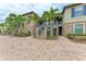 Exterior showcasing stone accents, palm trees, and stairways to multiple units and paved walkway at 13711 Messina Loop # 102, Lakewood Ranch, FL 34211