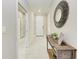 Inviting foyer with white tile flooring, console table, decorative mirror, and a view into adjacent rooms at 13711 Messina Loop # 102, Lakewood Ranch, FL 34211