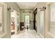 Hallway with white tile floors, seating area, and doors to a salon and office, all offering privacy and accessibility at 13711 Messina Loop # 102, Lakewood Ranch, FL 34211