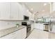 Bright kitchen with white cabinets, subway tile backsplash, stainless appliances, and open layout at 13711 Messina Loop # 102, Lakewood Ranch, FL 34211
