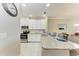 Well-lit kitchen with white cabinets, granite countertops, and modern stainless steel appliances at 13711 Messina Loop # 102, Lakewood Ranch, FL 34211