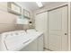 Well-organized laundry room with beach-themed decor and shelving at 13711 Messina Loop # 102, Lakewood Ranch, FL 34211