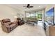 Comfortable living room featuring tile floors, a ceiling fan, plush seating, and a sliding glass door to the patio at 13711 Messina Loop # 102, Lakewood Ranch, FL 34211
