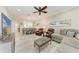 Bright living room featuring a ceiling fan, comfortable furniture, and open access to the dining area at 13711 Messina Loop # 102, Lakewood Ranch, FL 34211