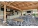 Covered outdoor bar and dining area with multiple TVs and a cozy fireplace overlooking landscaped grounds at 13711 Messina Loop # 102, Lakewood Ranch, FL 34211