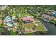 This aerial view showcases a beautiful home on a waterfront lot with a pool and mature landscaping at 1475 Bayshore Dr, Englewood, FL 34223