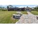 The backyard features a stone table with benches and brick pavers leading to the house at 1475 Bayshore Dr, Englewood, FL 34223