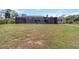 Expansive backyard featuring a screened-in lanai with a pool and a fire pit area, perfect for outdoor living at 1475 Bayshore Dr, Englewood, FL 34223