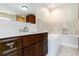 Elegant bathroom showcasing a vanity with dark wood cabinets, granite countertops, and a luxurious soaking tub at 1475 Bayshore Dr, Englewood, FL 34223