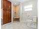 Accessible bathroom with a roll-in shower, tiled walls, a built-in bench, and a modern toilet for added convenience at 1475 Bayshore Dr, Englewood, FL 34223
