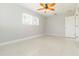 Bedroom featuring a ceiling fan, light gray walls, terrazzo flooring, window and door at 1475 Bayshore Dr, Englewood, FL 34223