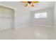 Bedroom featuring a ceiling fan, light gray walls, terrazzo flooring, and built in closet at 1475 Bayshore Dr, Englewood, FL 34223