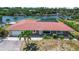 Charming single-story waterfront home with a red tile roof and screened lanai overlooking the canal at 1475 Bayshore Dr, Englewood, FL 34223