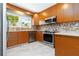 Updated kitchen showcasing stainless steel appliances, shaker cabinets, and tile backsplash, creating a modern aesthetic at 1475 Bayshore Dr, Englewood, FL 34223