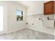 Bright laundry room with tiled floors, a window and a utility sink at 1475 Bayshore Dr, Englewood, FL 34223