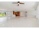 Open living space with tile flooring, ceiling fan, and a partial view of the kitchen at 1475 Bayshore Dr, Englewood, FL 34223