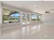Bright living room with a view of the pool and outdoor living space, featuring terrazzo flooring and neutral walls at 1475 Bayshore Dr, Englewood, FL 34223